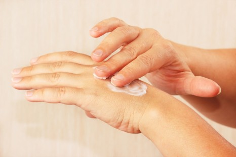 Female hands using skin cream
