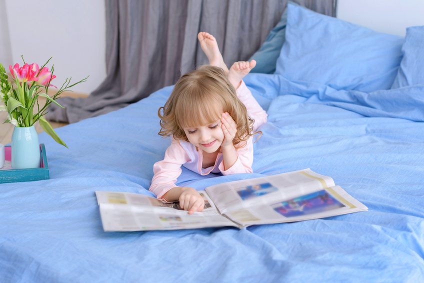 portrait of beautiful girl reading a newspaper at home/in the news/modern children